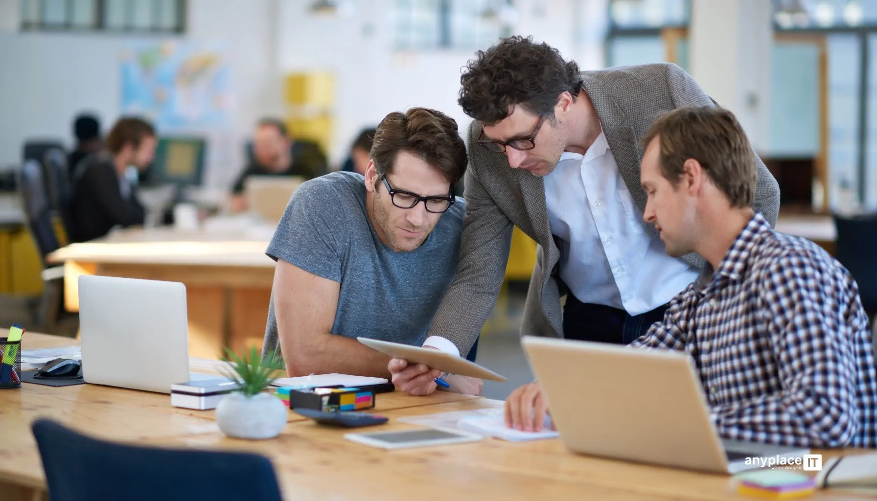 Team diskutiert mit Tablet im Büro