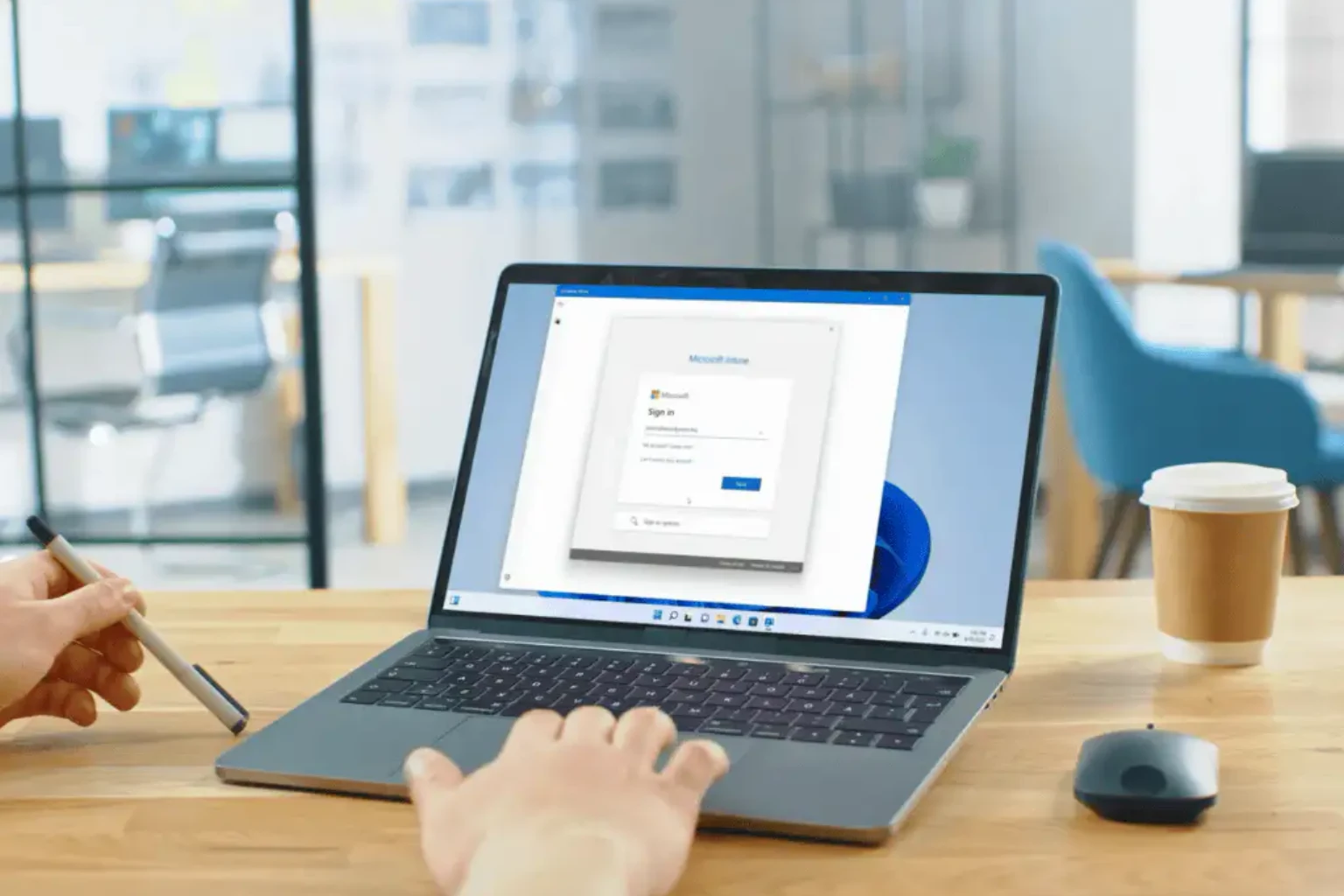 Person arbeitet an einem Windows-Laptop im Büro.