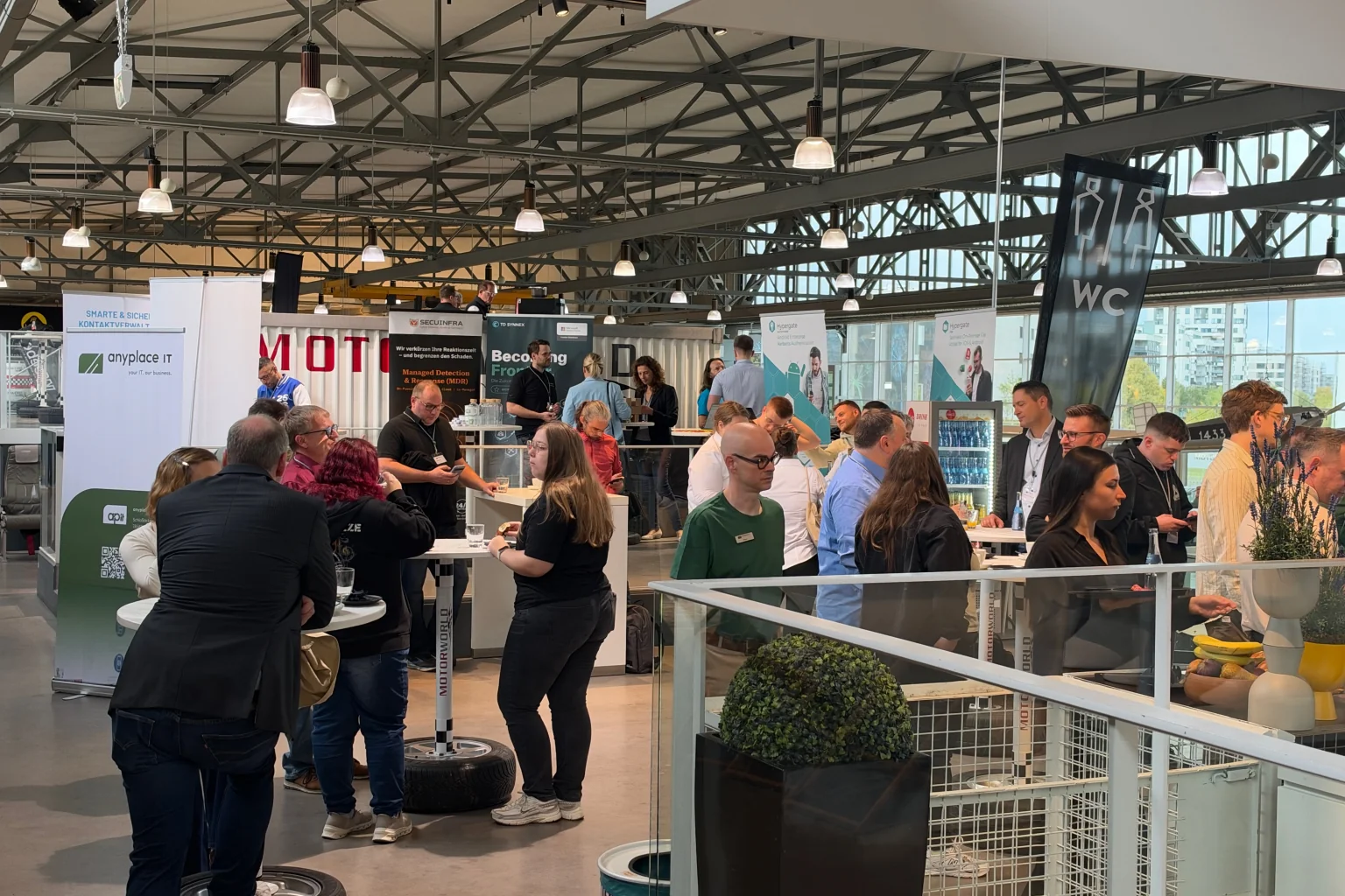 Teilnehmer im Gespräch im Ausstellungsbereich des Enterprise TechDay 2026 in der Motorworld Böblingen.